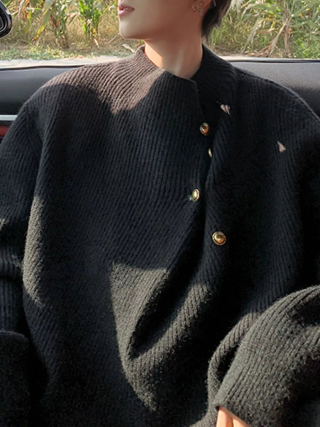 Men's dark knitted sweater with ribbed crew neck and gold-tone button placket