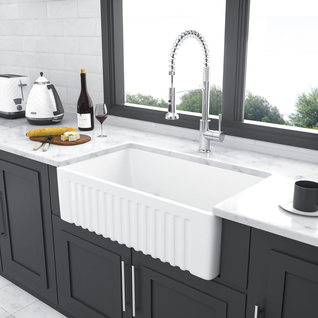 White farmhouse-style apron ceramic kitchen sink with single basin and drain opening