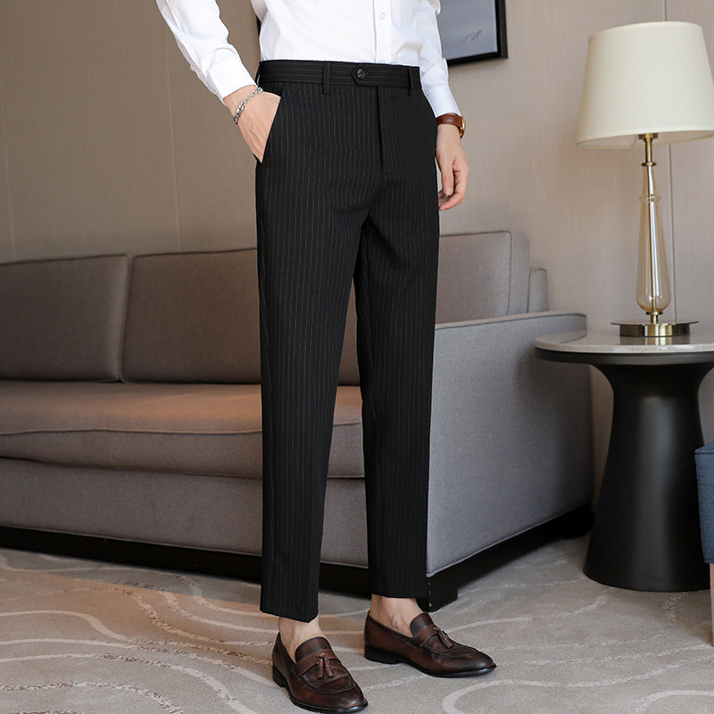 Men's slim-fit black pinstripe trousers with belt loops and tapered straight leg