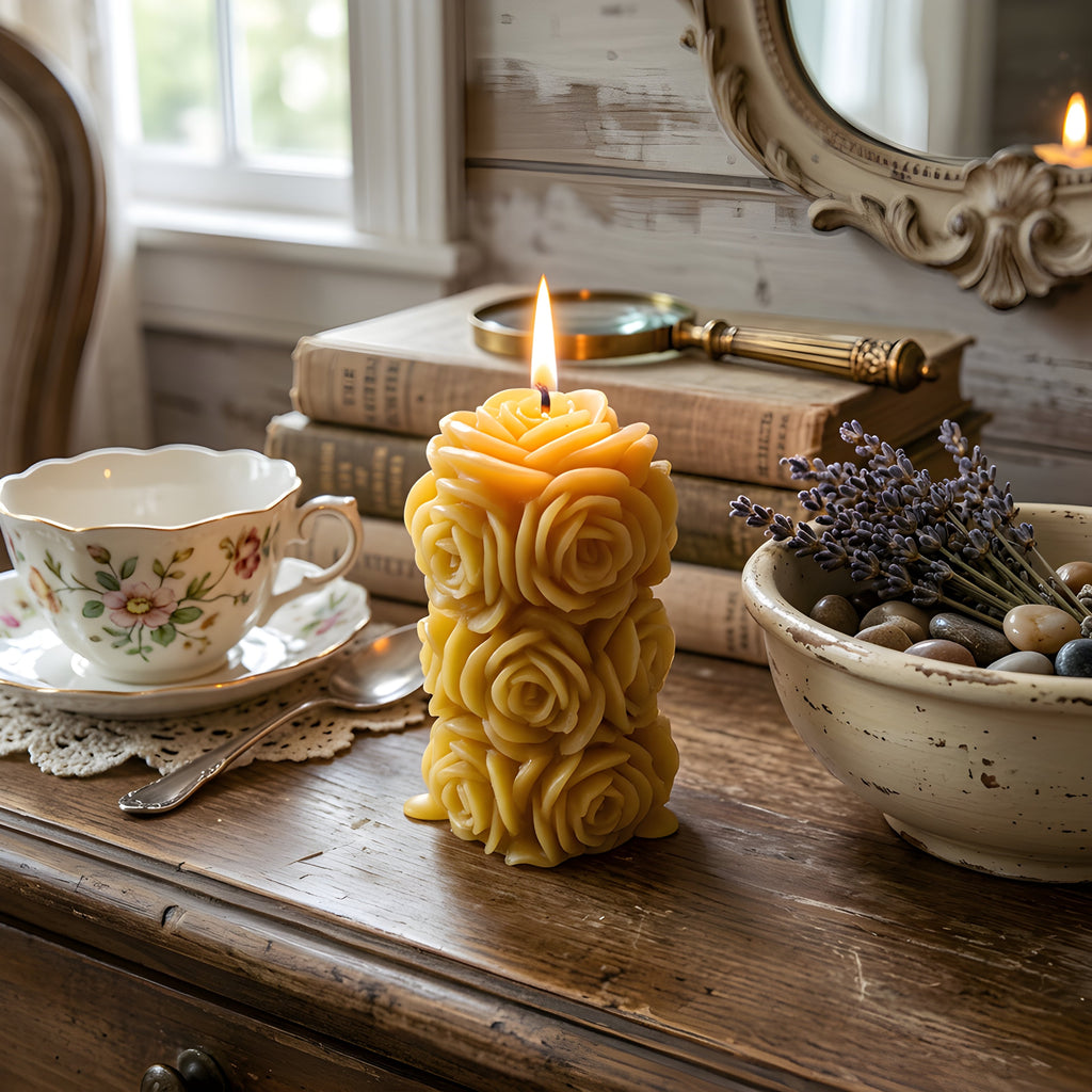 Rose-shaped yellow beeswax candle with layered petals and a lit wick