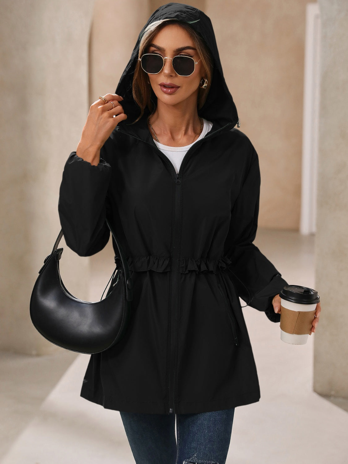 Black hooded waterproof jacket with zip front and cinched waist, long sleeves