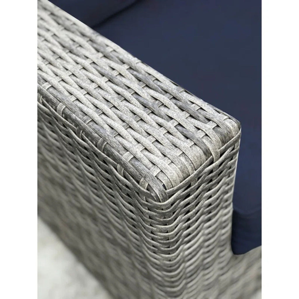 Close-up of woven wicker armrest texture with blue seat cushion