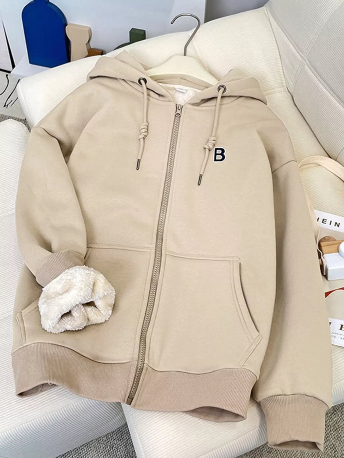 Apricot fleece-lined zip-up hoodie with hood, full-length zipper, drawstring ties.