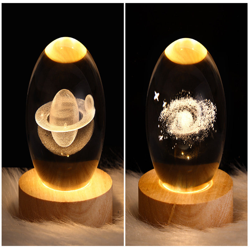 Two galaxy crystal ball table lamps with glowing planet and spiral star patterns