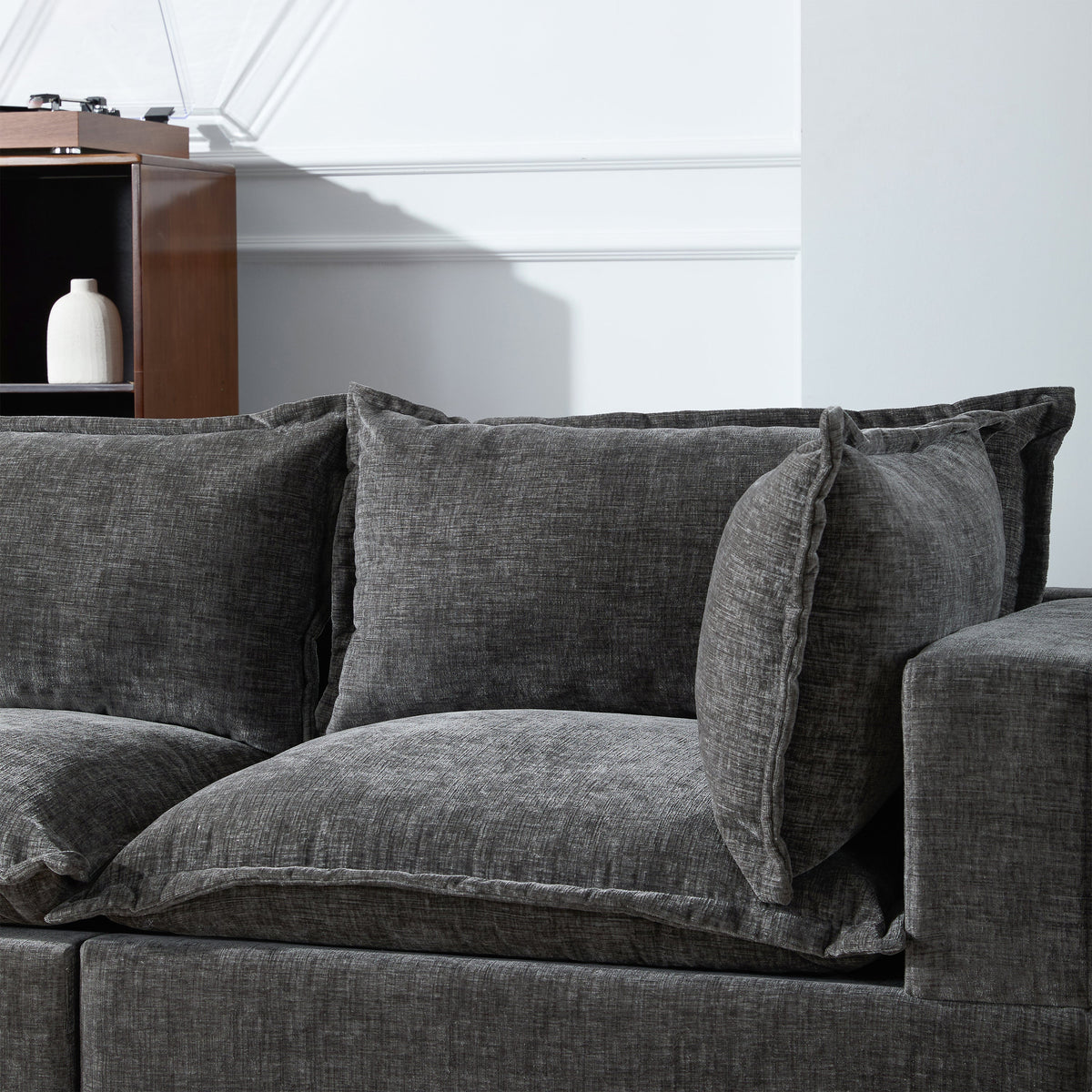 Gray chenille sectional sofa seat with back cushions and two throw pillows.