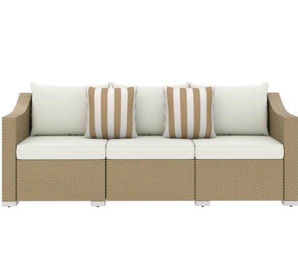 Beige rattan sofa with three white seat cushions and two striped throw pillows