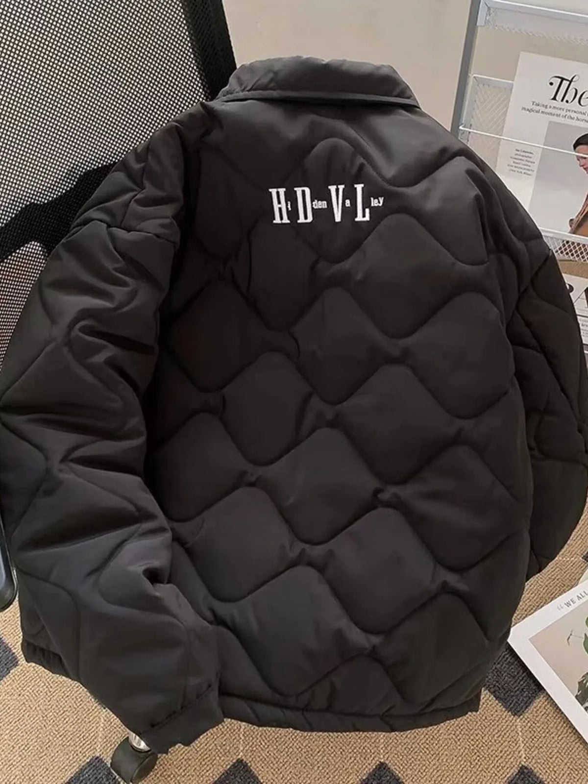 Men's quilted black zip-up jacket back view with embroidered logo on yoke