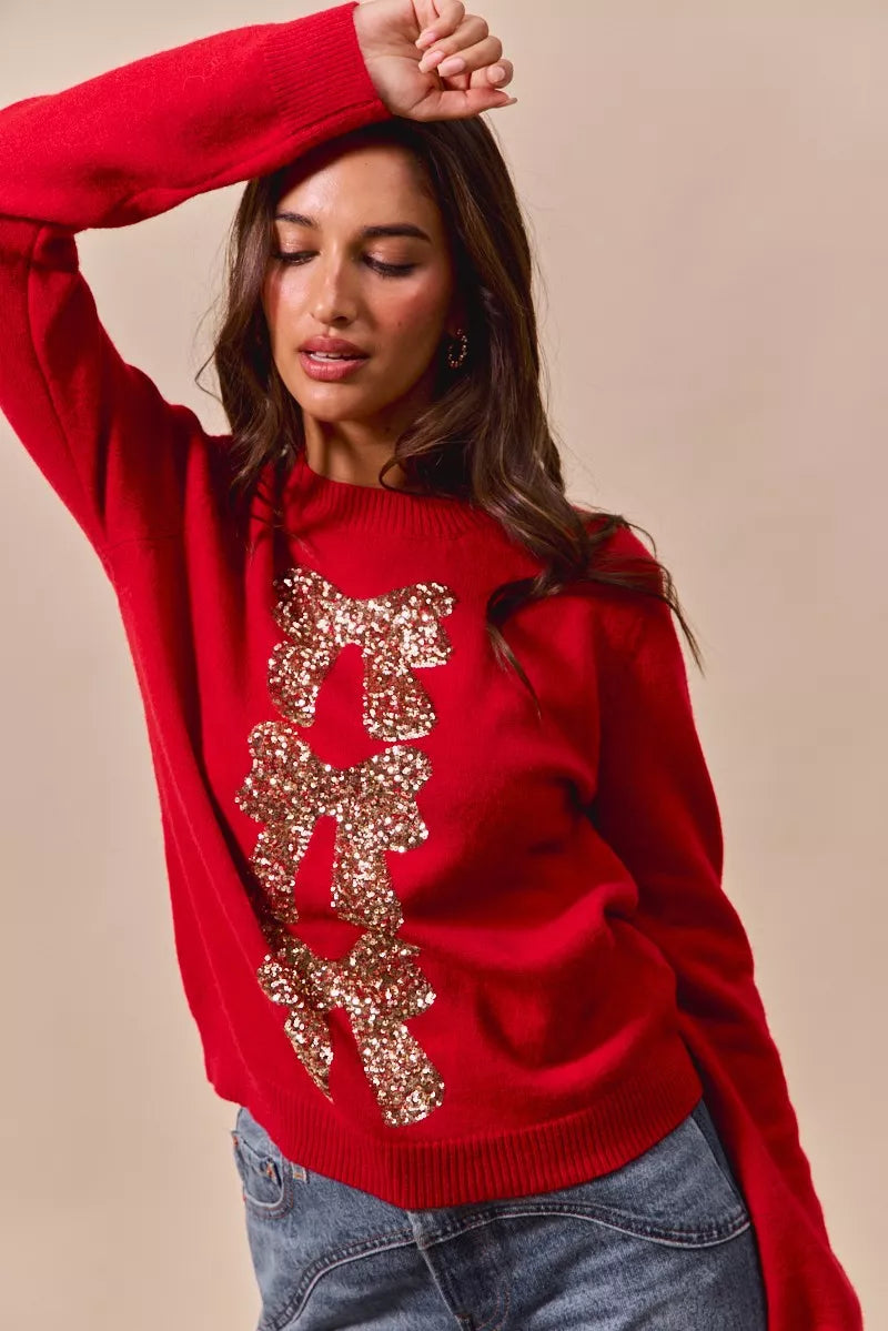 Red knit sweater with gold sequin bow ribbon motif and ribbed sleeve cuffs