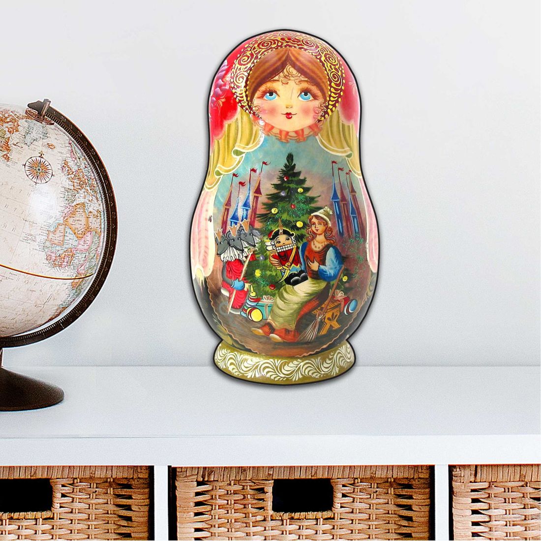 Large nesting doll ornament with nutcracker scene, shown on a golden base