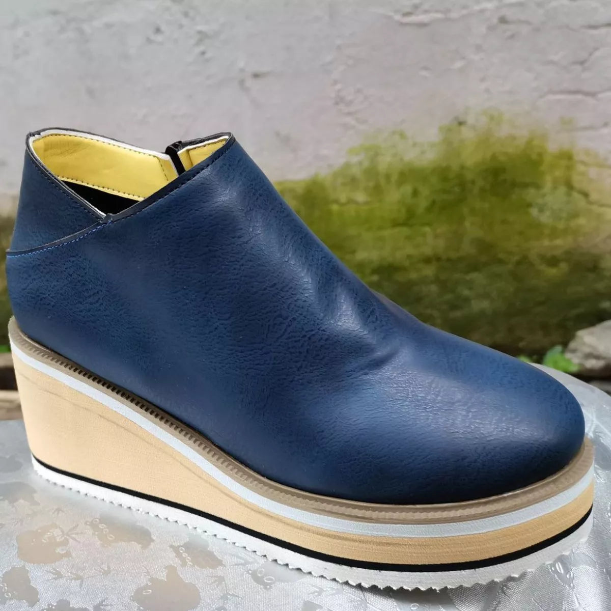 Blue ankle wedge boots with side zipper and cream striped midsole