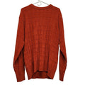 Orange textured knit crewneck sweater with grid pattern and long sleeves