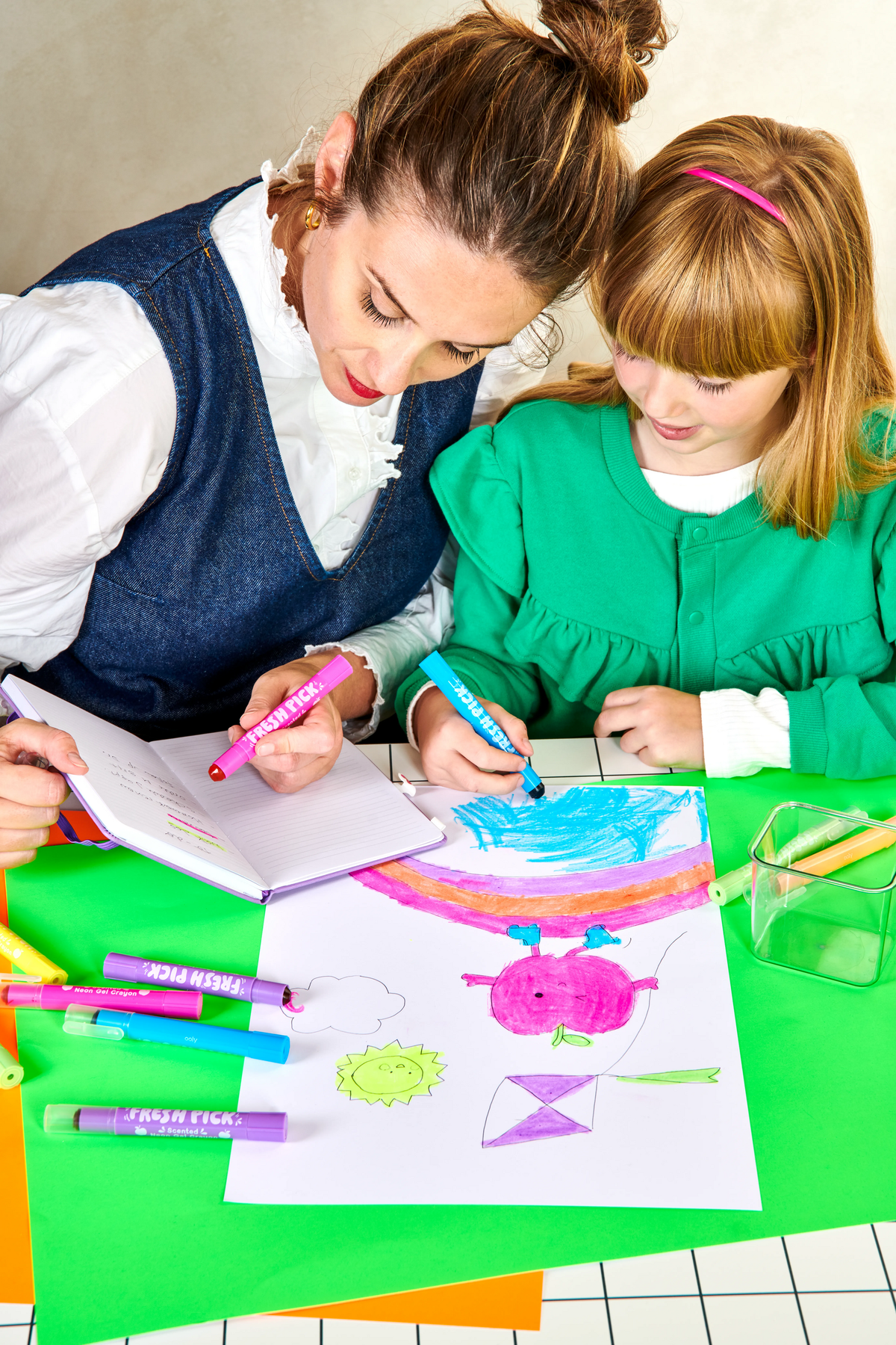 Adult and child coloring with neon gel crayons on paper