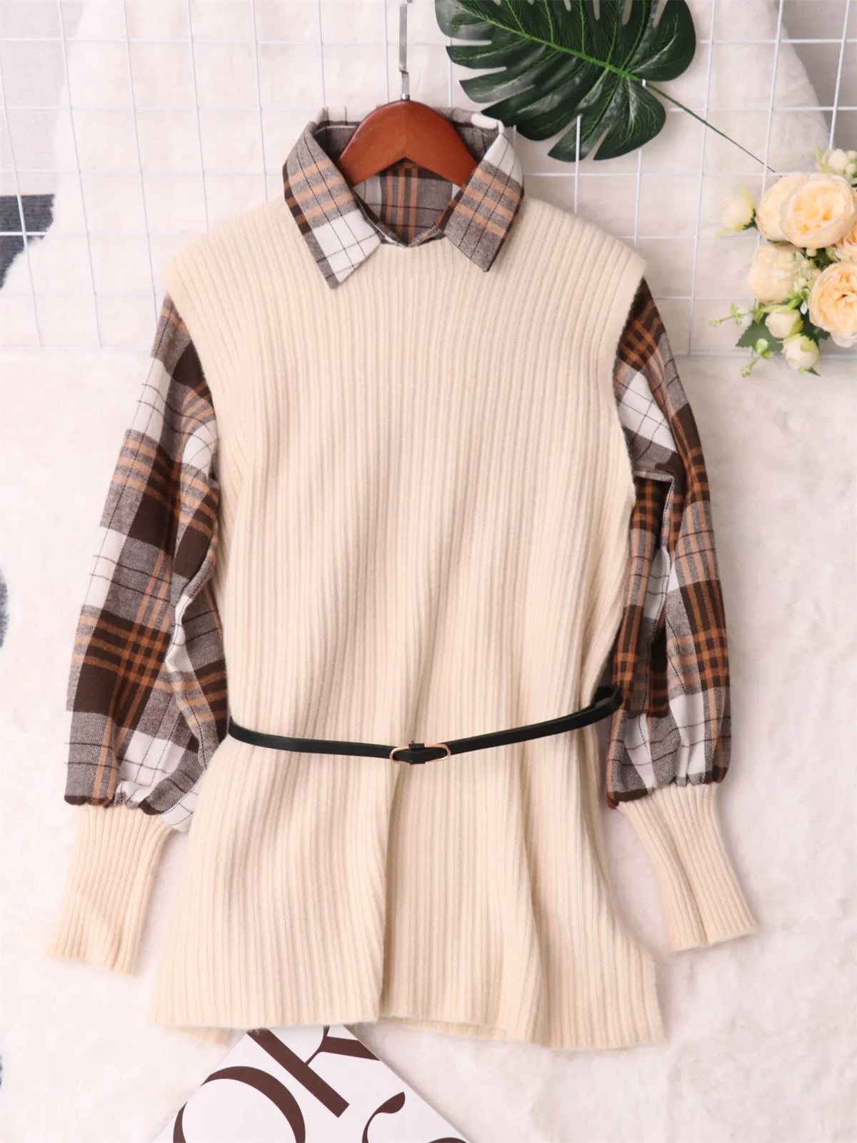 Cream long-sleeve sweater dress with ribbed knit body, plaid sleeves, and black belt