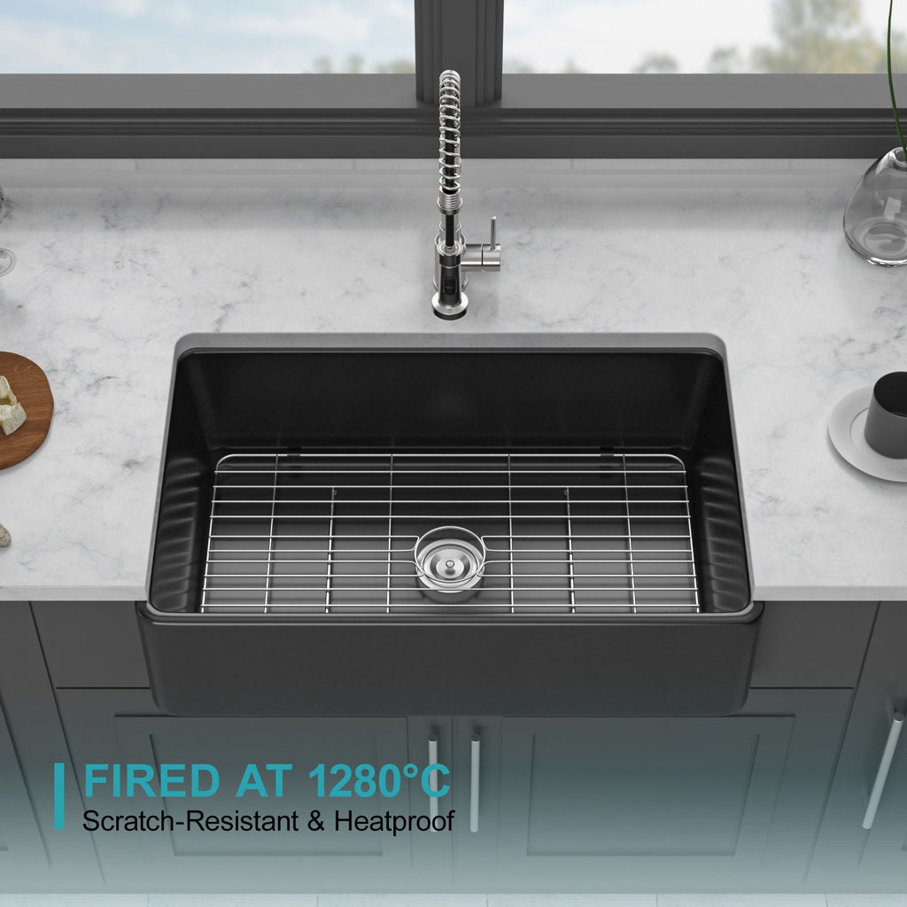 Black single-bowl ceramic kitchen sink with wire rack inside and centered drain