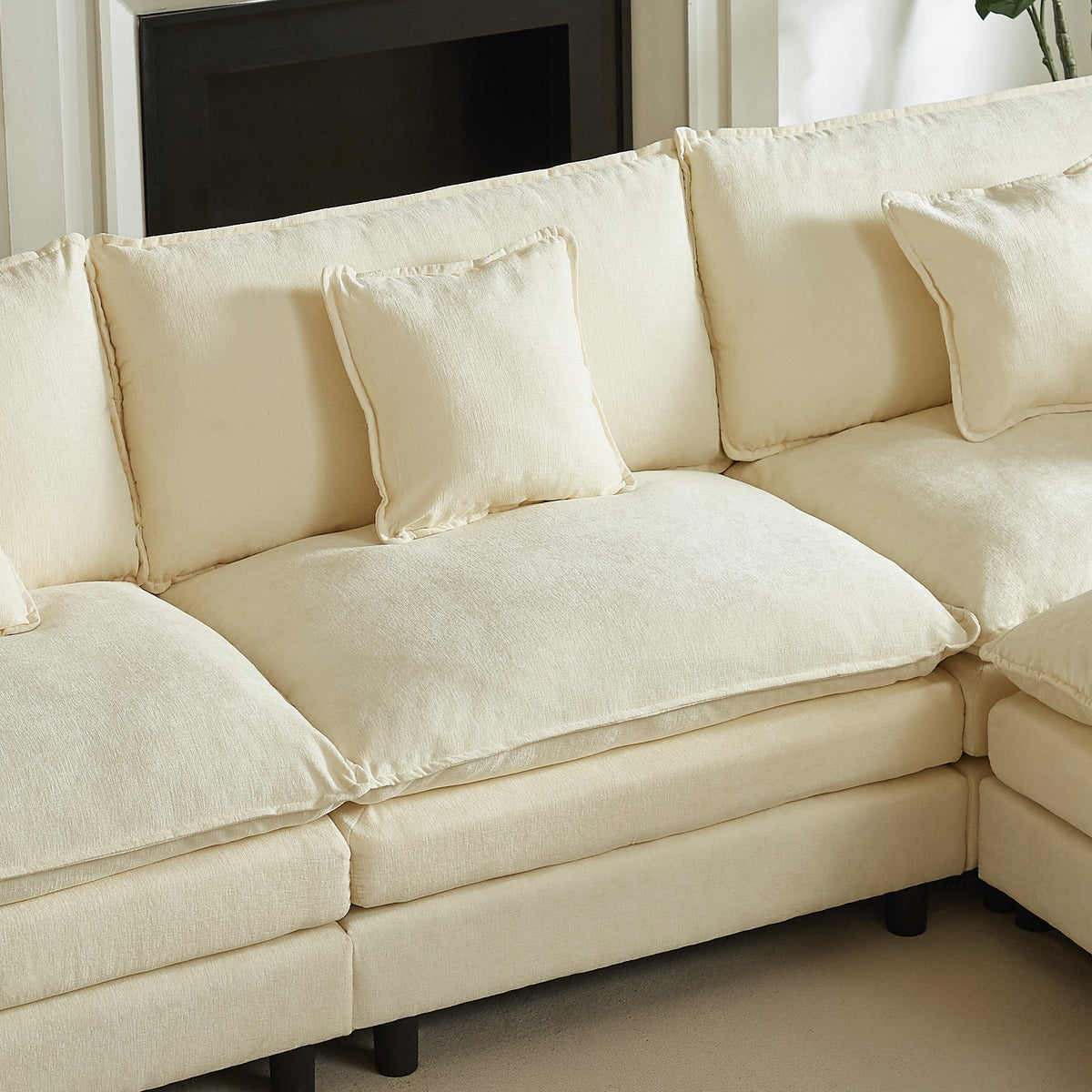 Cream chenille sectional sofa chaise seat with layered cushions and two throw pillows