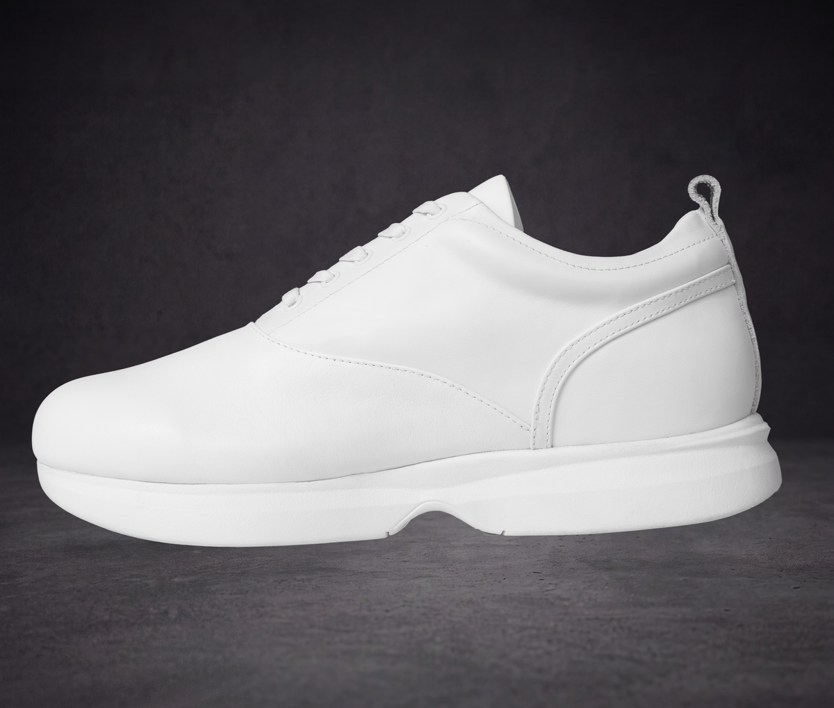 White low-top sneaker with curved side panel and WOA branding on heel