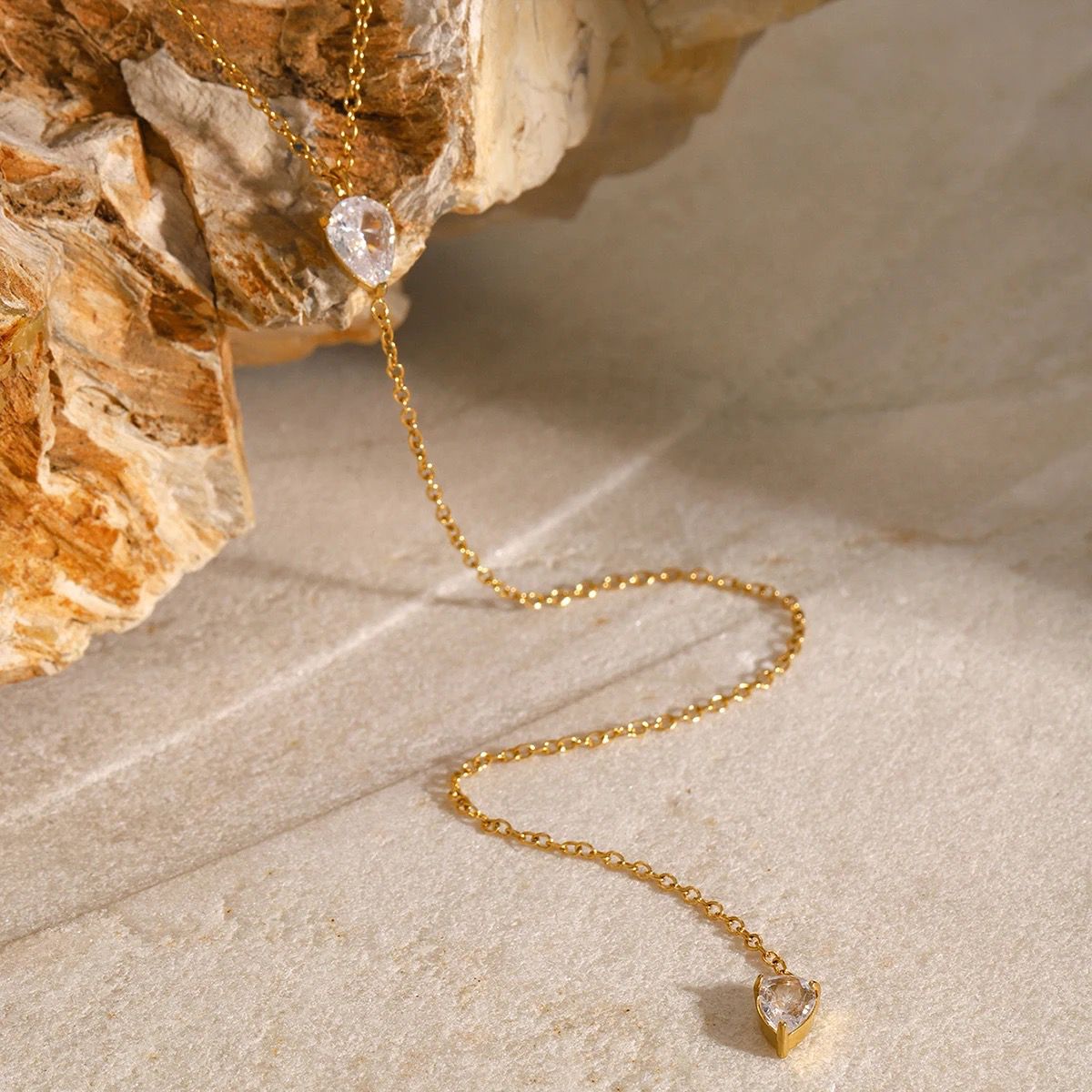 Gold-tone long necklace with faceted teardrop crystal drop at end