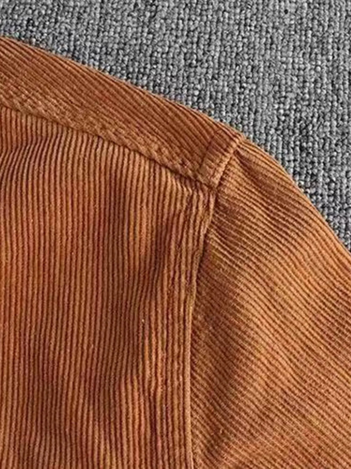 Corduroy shirt seam detail close-up on front panel with vertical rib texture