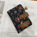 Tri-fold wallet with dark floral print, top clasp and front card pockets