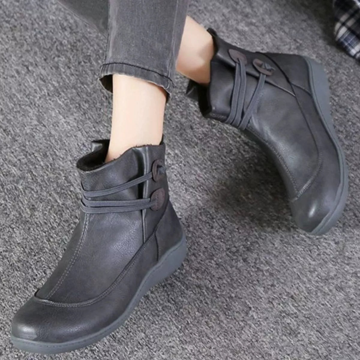 Dark gray ankle boots with button-detail straps and lace-up top, low sole.