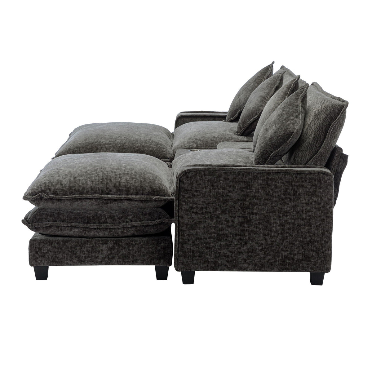 Dark gray sectional sofa corner with ottoman and stacked arm pillows