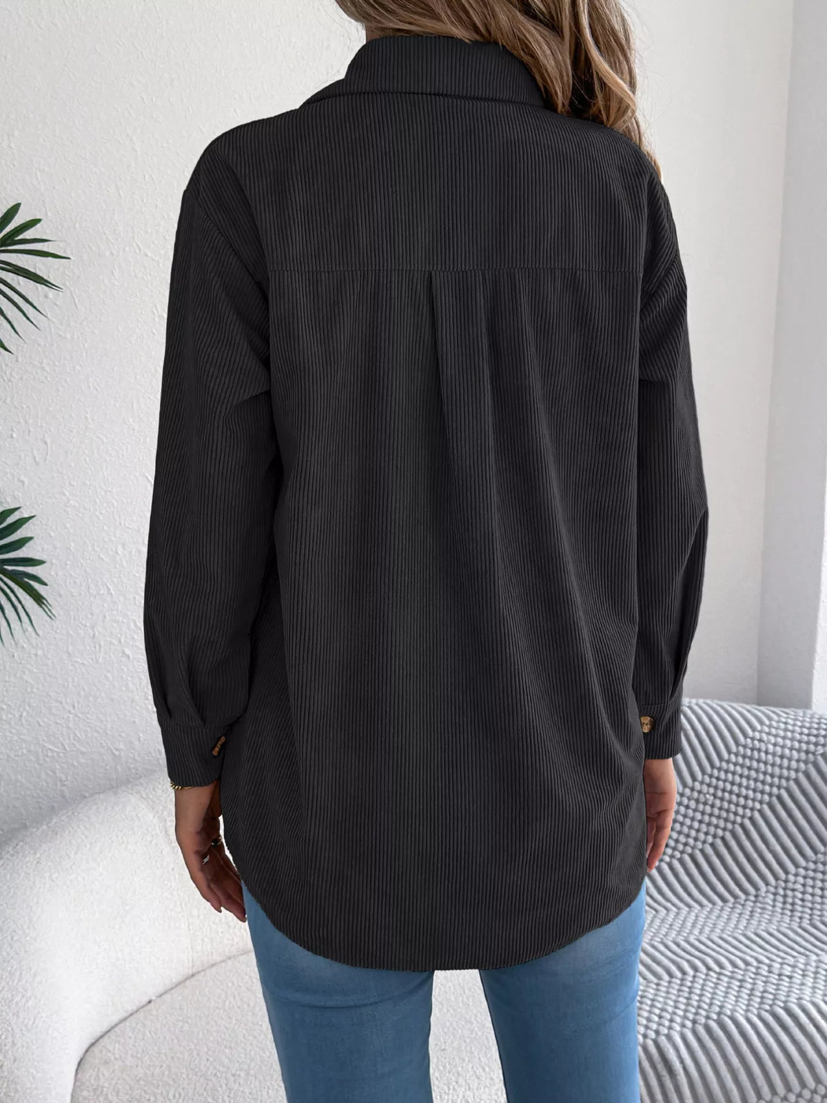 Black corduroy shacket back view with buttoned placket and long sleeves.