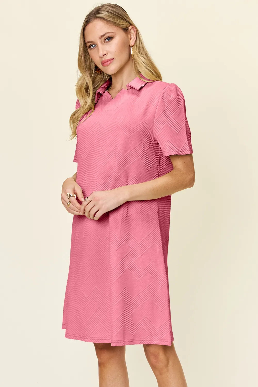 Pink textured collared short-sleeve dress with V neckline and straight hemline.