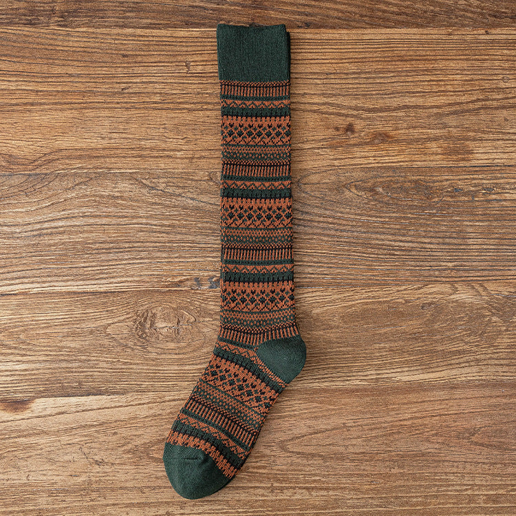 Children’s knee-length socks with dark green cuffs and orange-and-black striped pattern.