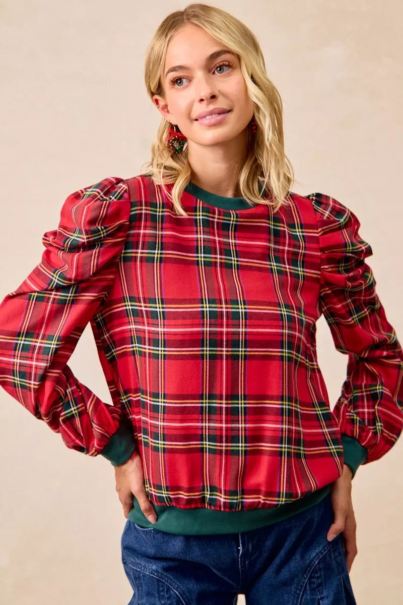 Red plaid blouse with puff shoulders, long sleeves, and green trim at neckline and cuffs