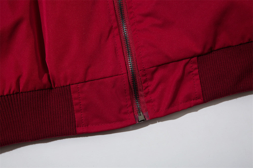 Red jacket coat close-up: ribbed cuffs and elastic hem near front zipper