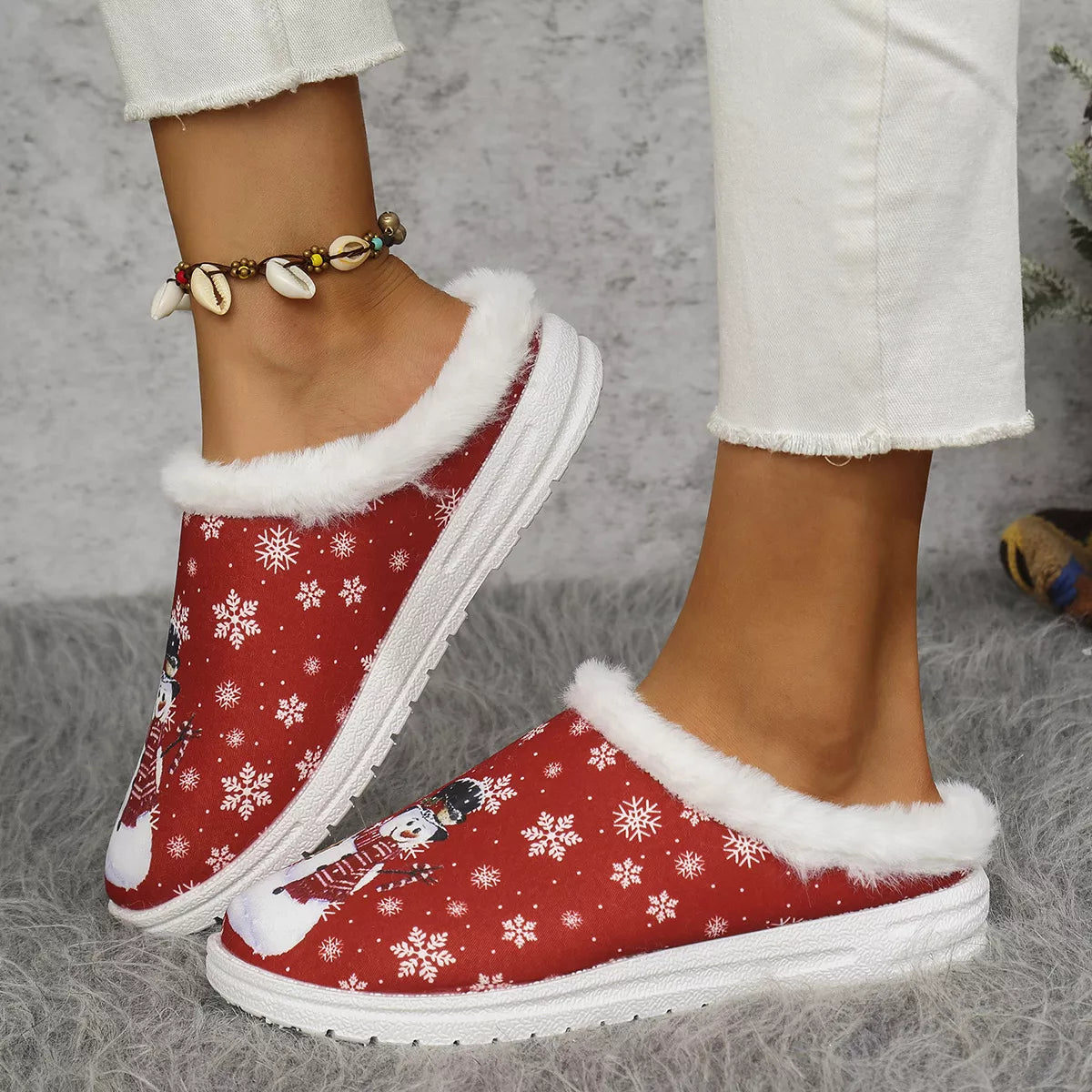 Red plush-lined slip-on sneakers with white faux-fur collar and snowflake print