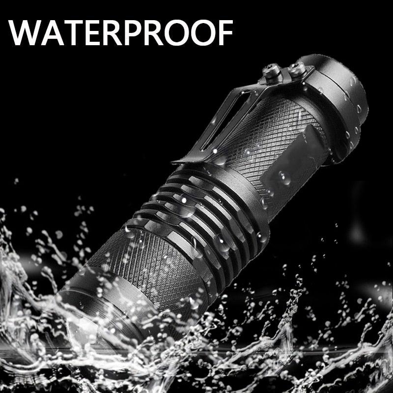 Mini handheld LED flashlight with textured grip and metal head, water splash effects