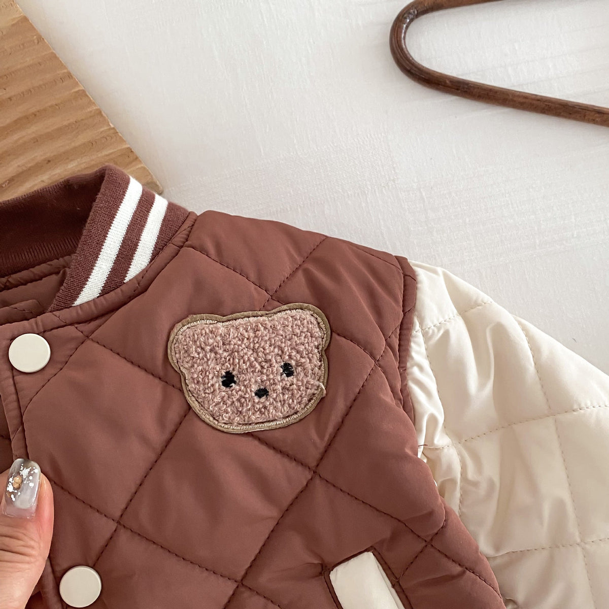Kids reddish-brown quilted jacket with bear applique, snap front, and striped collar