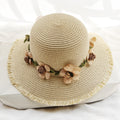 Womens straw sun hat in light beige with floral trim around the crown