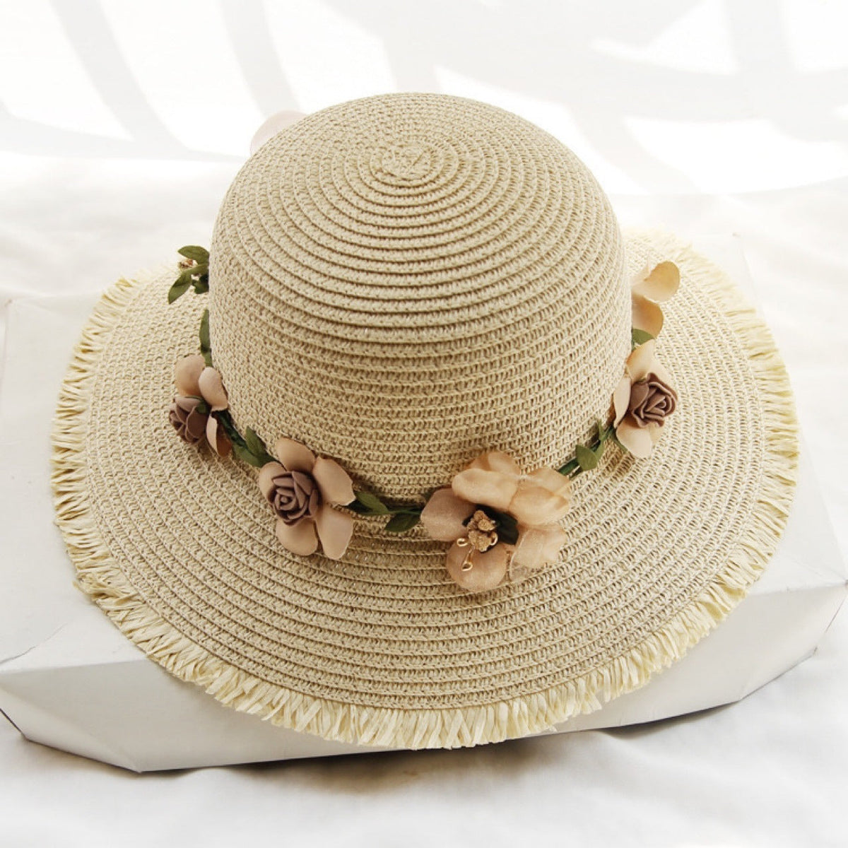 Womens straw sun hat in light beige with floral trim around the crown
