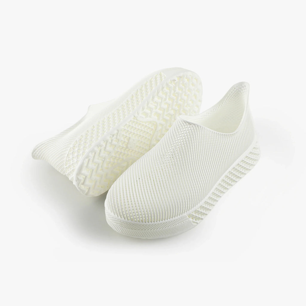 Light-colored 3D printed slip-on sneakers, curved knit upper and ridged sole