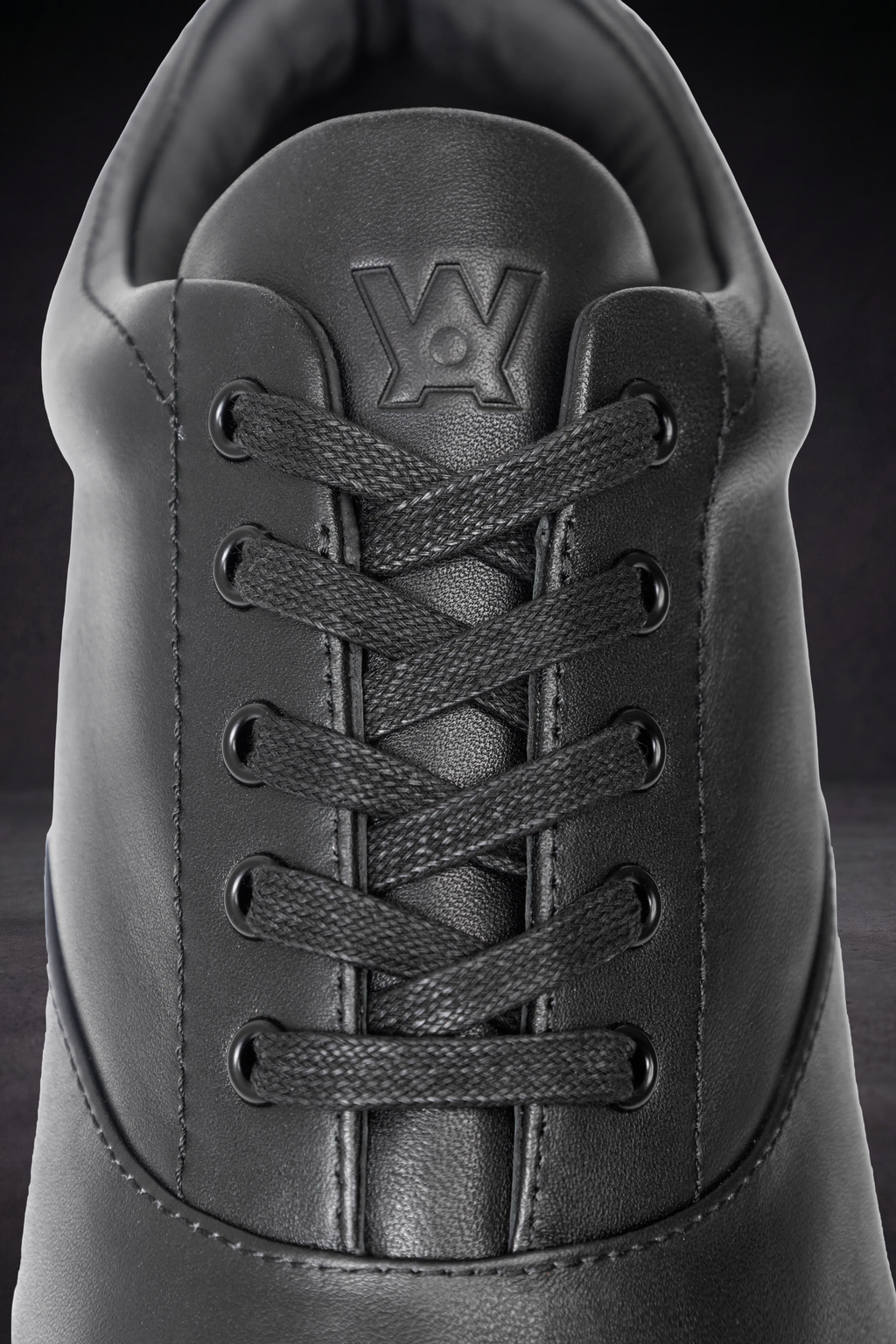 WOA sneaker tongue and laces detail, textured leather with stitched WOA logo