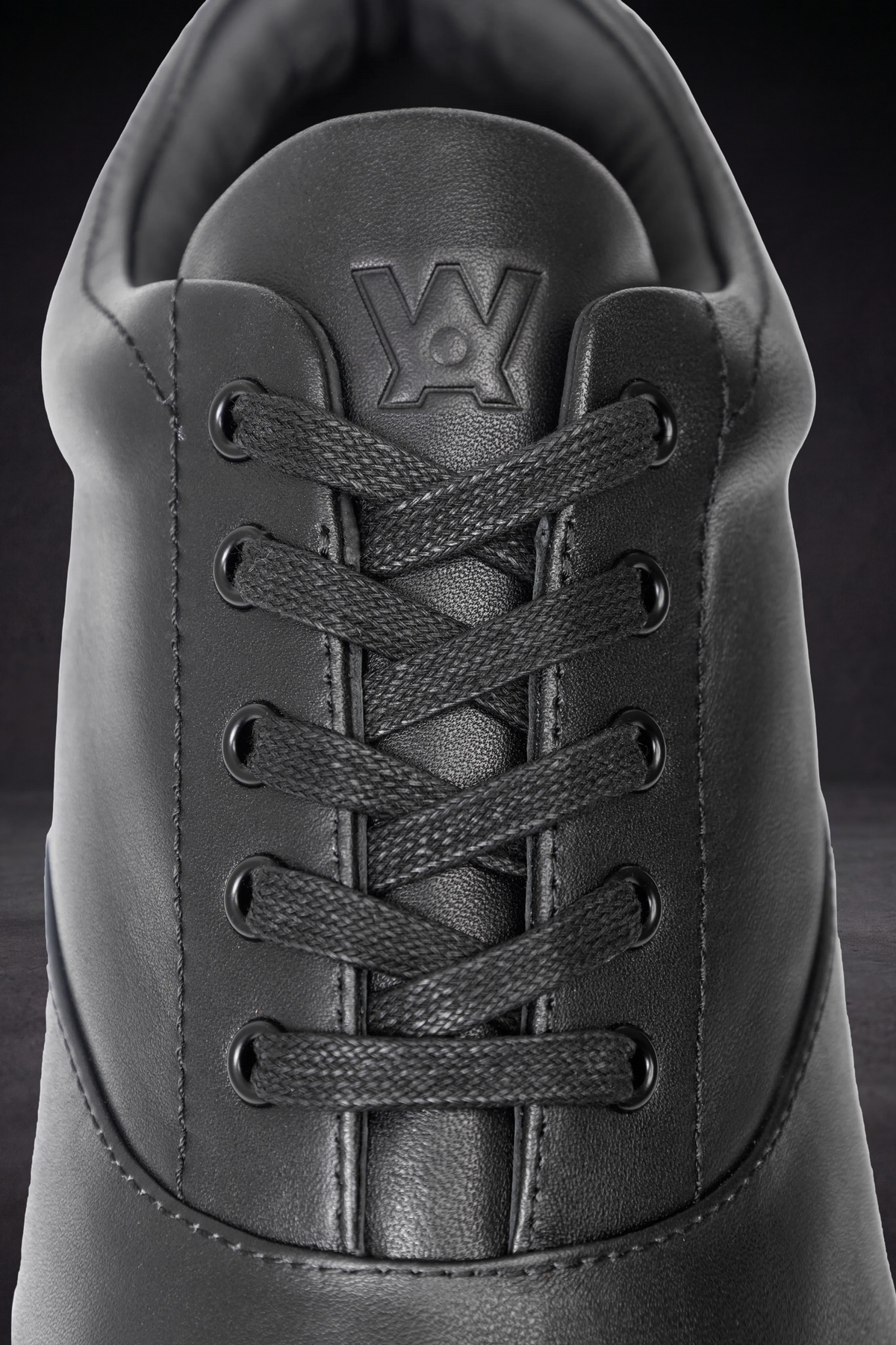 WOA sneaker tongue and laces detail, textured leather with stitched WOA logo