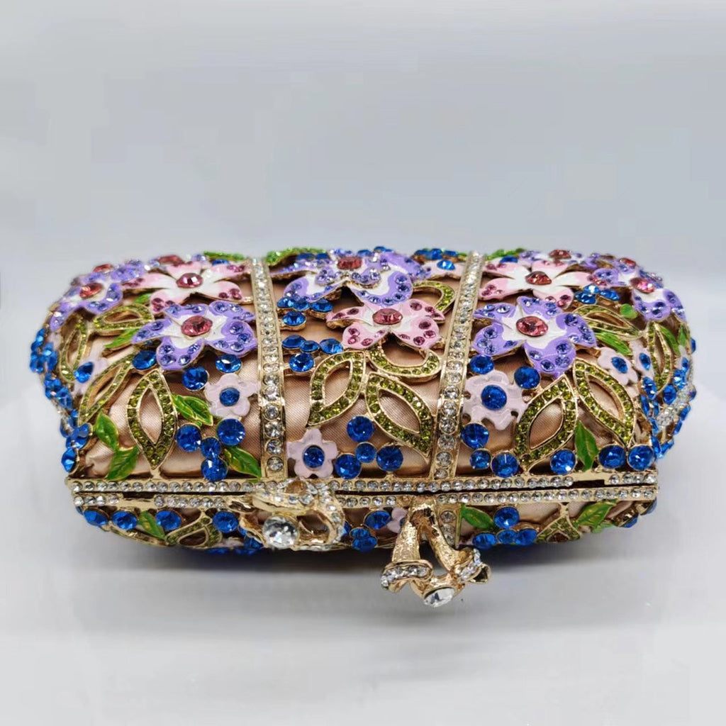 Jeweled floral evening clutch with blue rhinestones, purple and pink enamel, and gold-tone clasp
