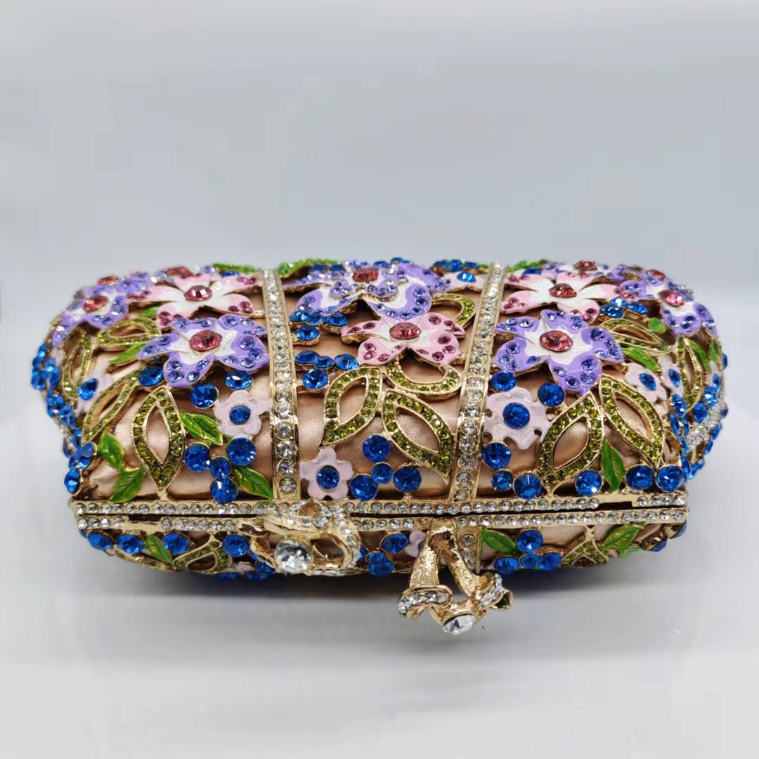 Jeweled floral evening clutch with blue rhinestones, purple and pink enamel, and gold-tone clasp