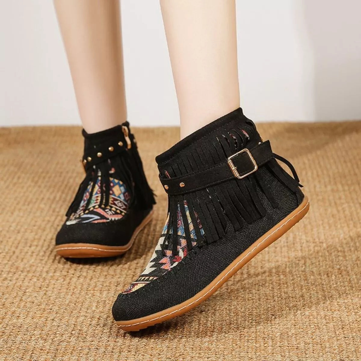 Black fringe ankle boots with side zipper, buckle strap, and patterned fabric panel