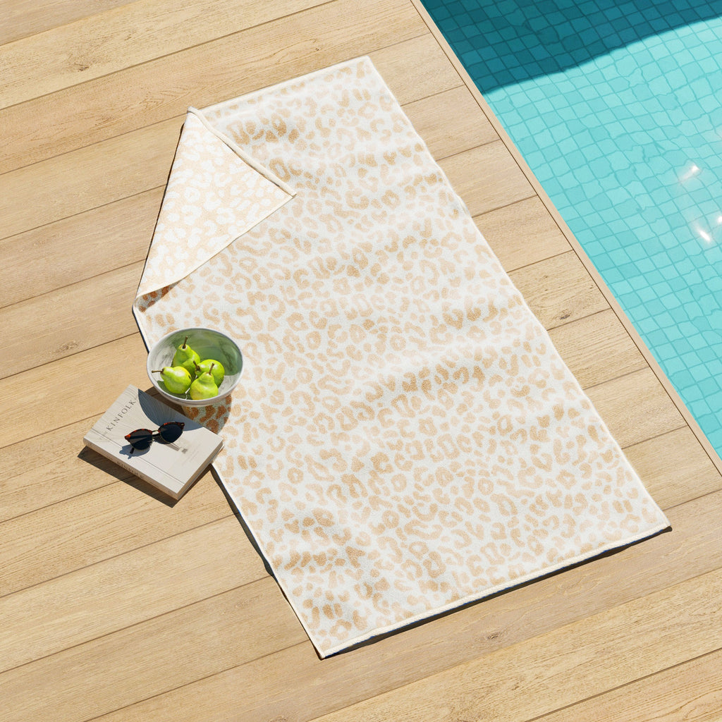 Cotton velour beach towel with beige leopard-print design and stitched border