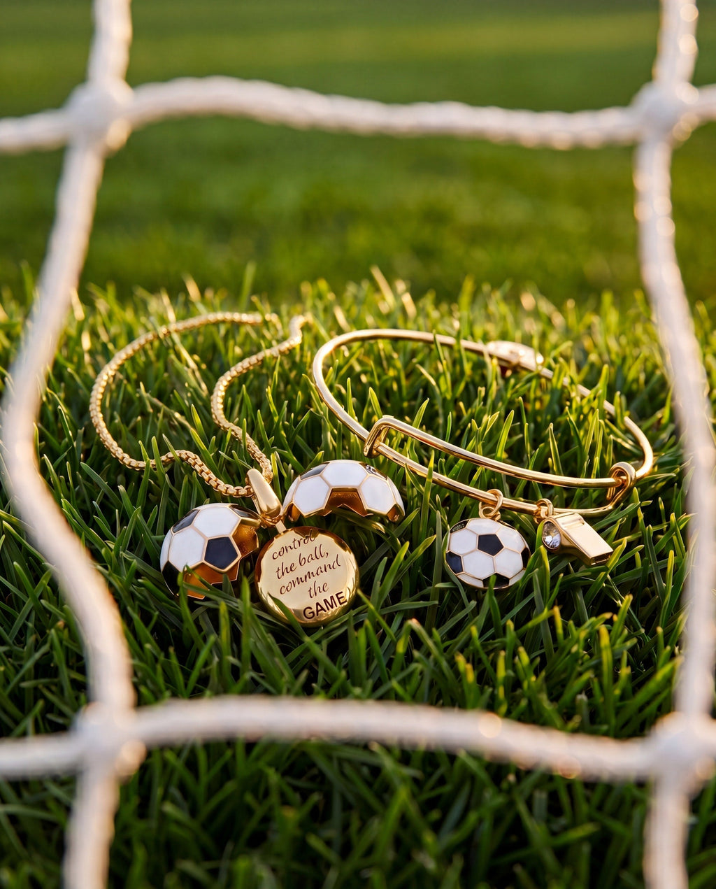 Gold soccer ball locket necklace set on grass near soccer goal