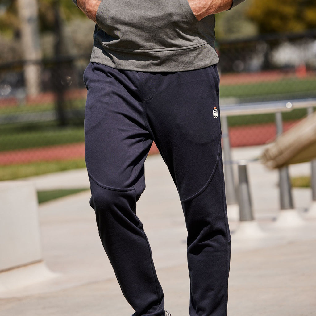 Navy jogger pants with tapered legs and elastic waistband, side logo patch.