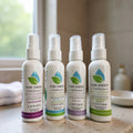 Set of four white pump lotion bottles with colorful lavender, lilac, and mint scent labels