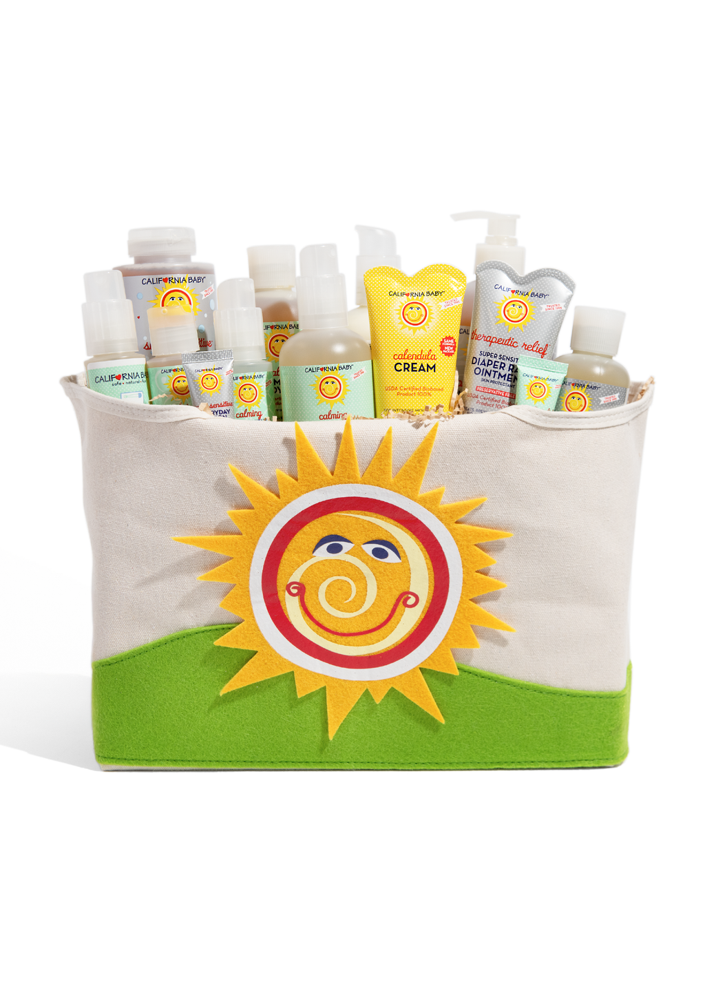 Beige fabric tote bag with sun logo and green base, filled with baby skincare bottles