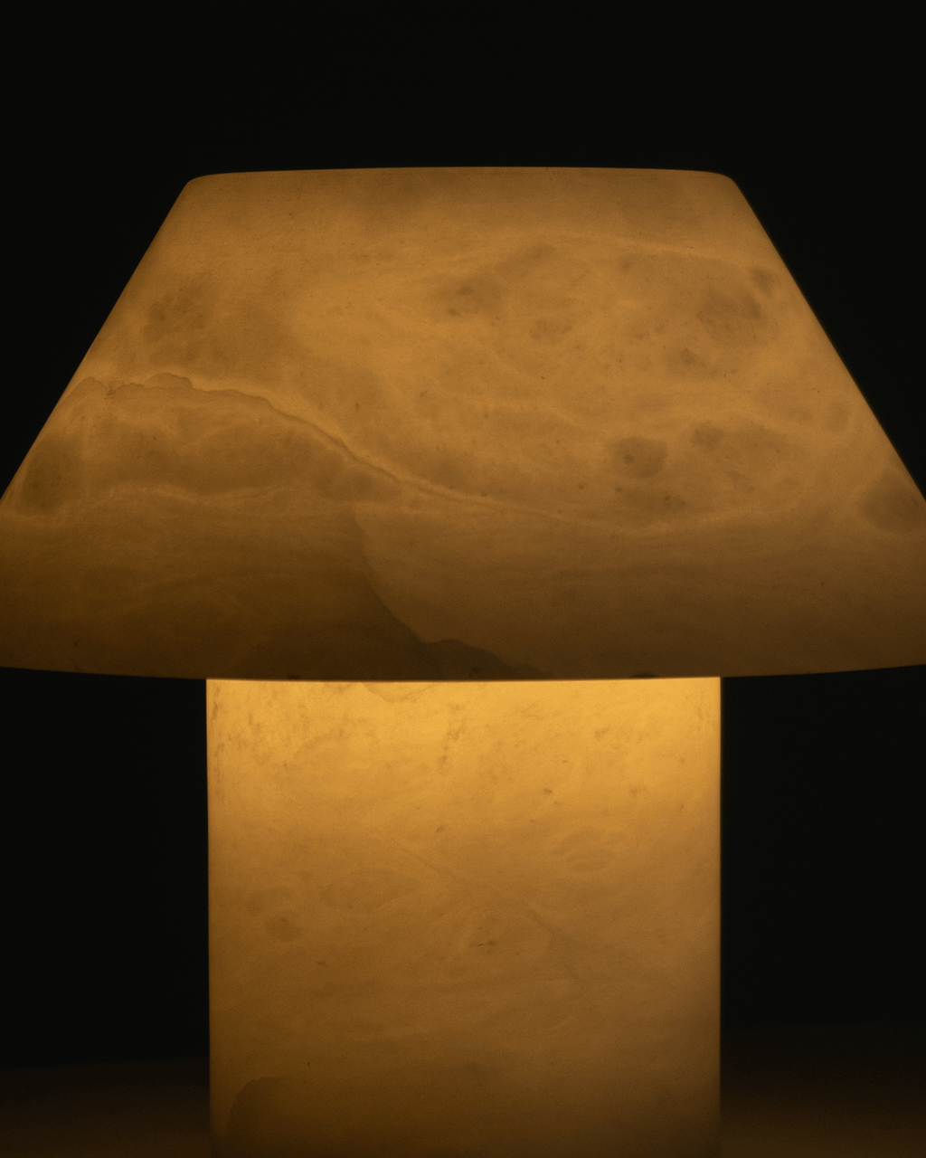 Close-up of warm fabric cone shade and cylindrical base of a table lamp