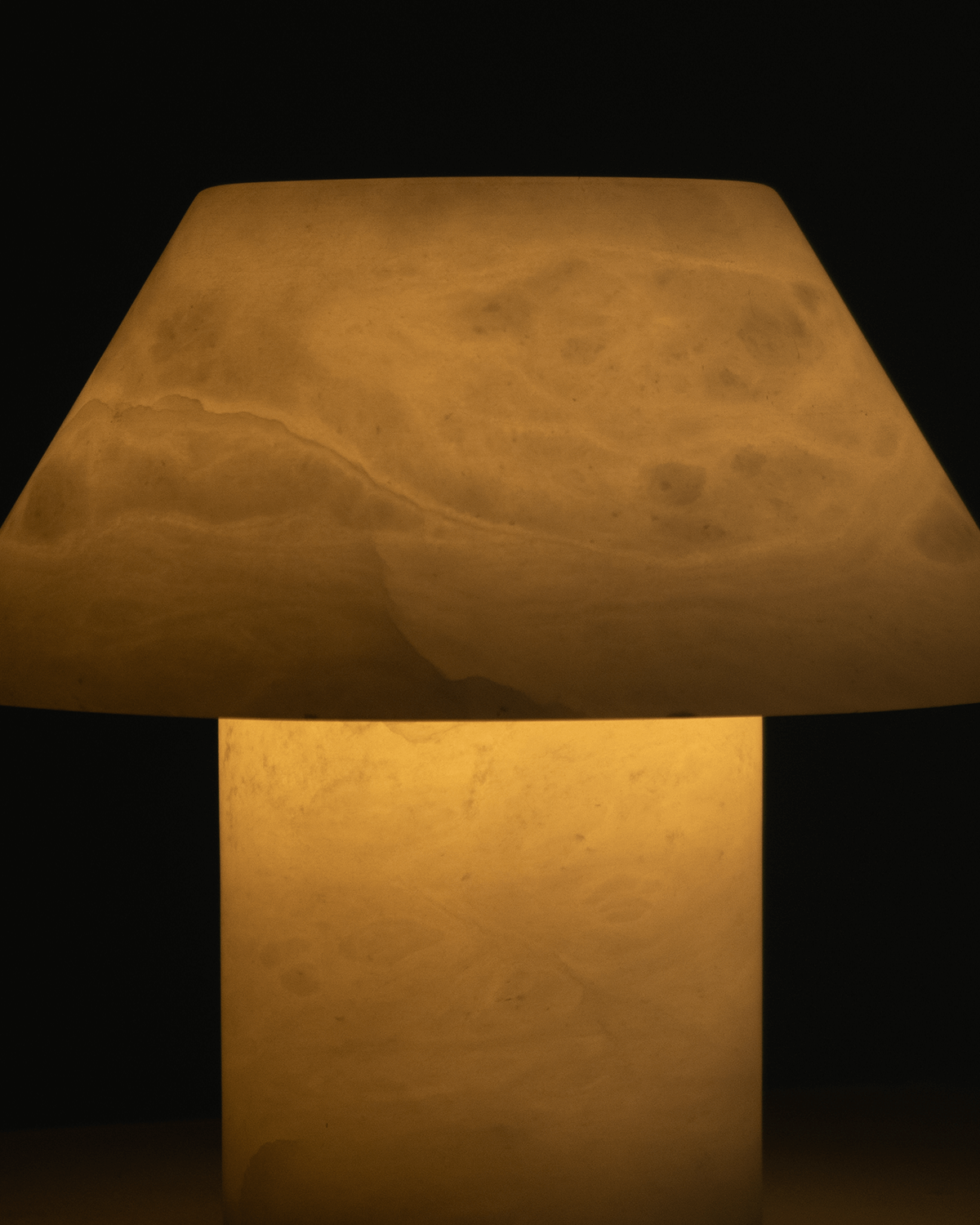 Close-up of warm fabric cone shade and cylindrical base of a table lamp