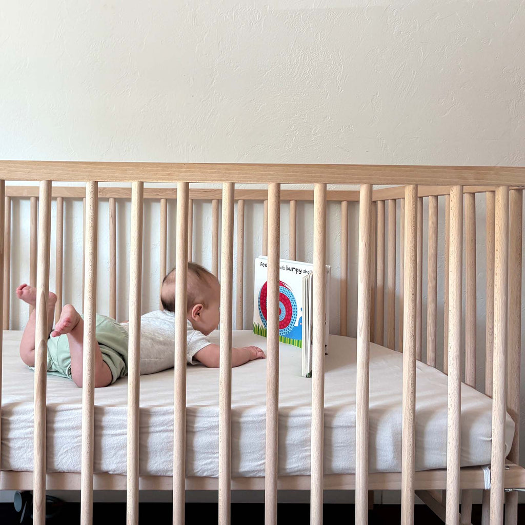 Crib sheet on a nursery crib mattress with a light, smooth fitted surface.