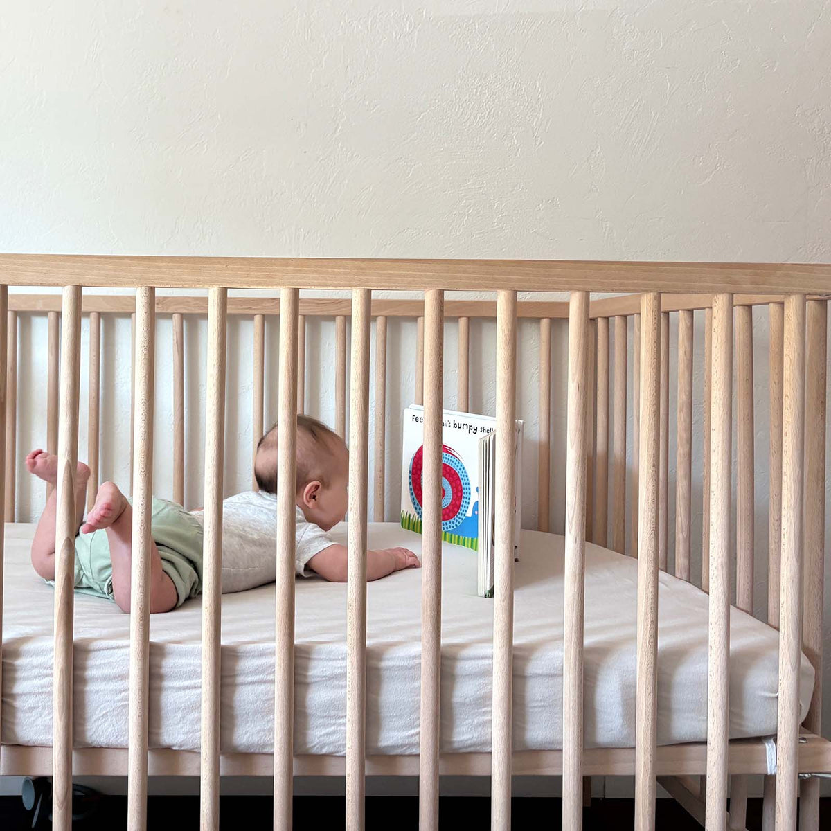 Crib sheet on a nursery crib mattress with a light, smooth fitted surface.